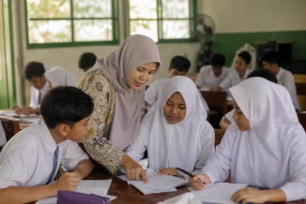 Guru mendampingi siswa meninjau dan memperbaiki pekerjaan dalam suasana belajar yang kolaboratif