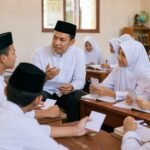 Guru memandu diskusi kelas dengan siswa yang menunjukkan kartu respons dan menulis jawaban